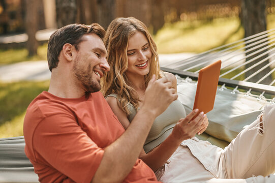 Smiling man and woman looking at tablet
