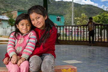 niñas Latinoamericanas andinas abrazándose y sonrriendo 