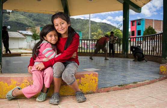 ni&ntilde;as Latinoamericanas andinas abraz&aacute;ndose y sonrriendo 