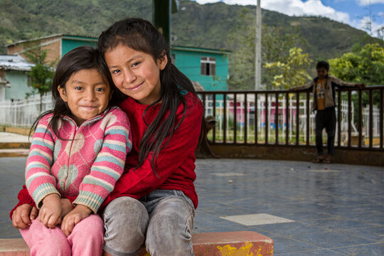 niñas Latinoamericanas andinas abrazándose y sonrriendo 
