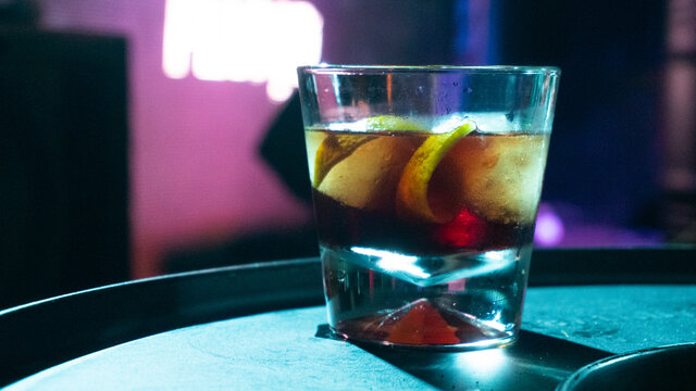 Negroni delicioso, bar escuro gelado, copo pequeno com laranja, casca e gelo