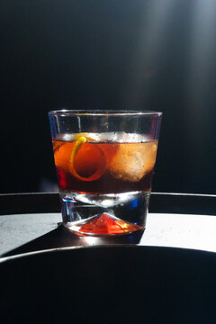 Negroni delicioso, bar escuro gelado, copo pequeno com laranja, casca e gelo