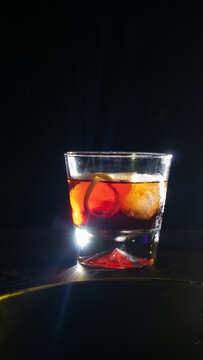 Negroni delicioso, bar escuro gelado, copo pequeno com laranja, casca e gelo