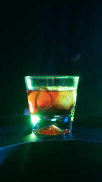Negroni delicioso, bar escuro gelado, copo pequeno com laranja, casca e gelo
