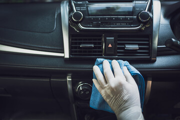 Man cleaning car dashboard. He was wearing white rubber gloves.