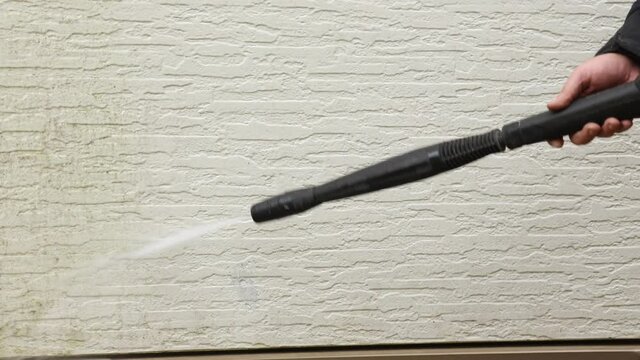 Man cleaning walls with high pressure power washer. Washing cladding walls house. High quality 4k footage