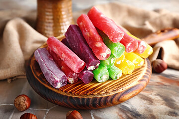 Board with tasty Turkish delight on marble background