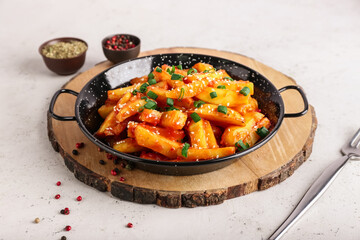 Plate with honey chilli potato on light background