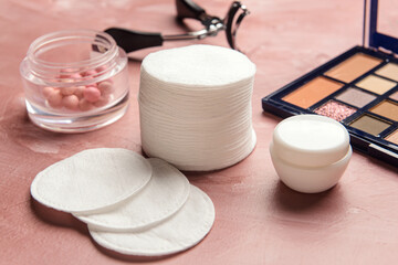 New cotton pads and decorative cosmetics on color background, closeup