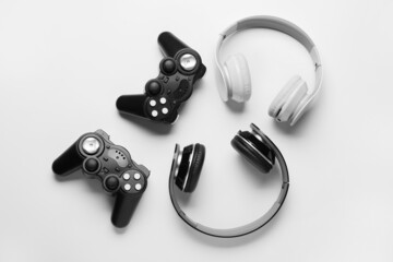 Modern joysticks and headphones on white background © Pixel-Shot