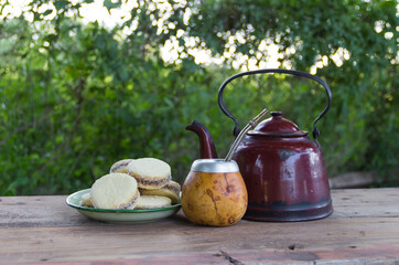Mate and kettle with a plate of alfajores and yerba mate infusion in the Argentine countryside