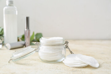 Glass jar with cotton pads on light table, closeup
