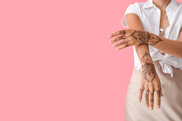 Beautiful Indian woman with henna tattoo on color background
