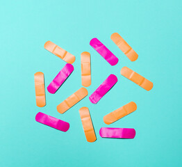 Pink and orange medical plasters on color background