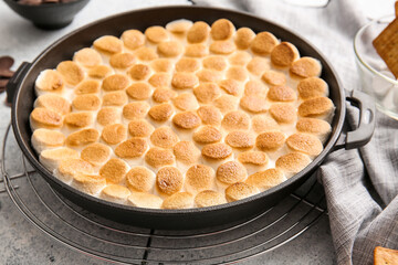 Frying pan with tasty S'mores dip on light background, closeup