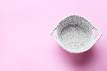 Stylish knitted basket on pink background