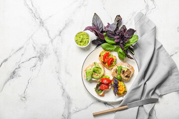 Plate with tasty vegetarian bruschettas and sauce on light background
