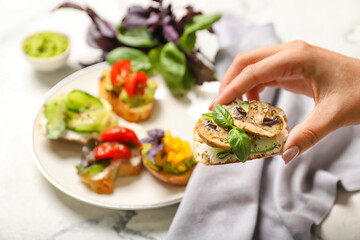 Female hand with delicious vegetarian bruschetta, closeup