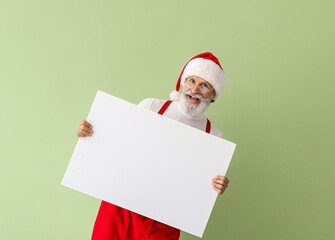 Santa Claus with blank poster on color background