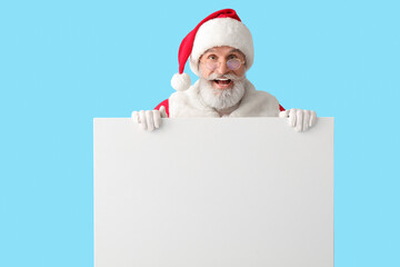 Santa Claus with blank poster on color background