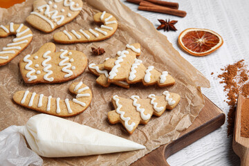 Fototapeta na wymiar Board with Christmas gingerbread cookies on light background