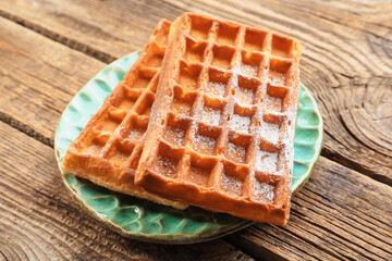 Plate with delicious Belgian waffles on wooden background, closeup