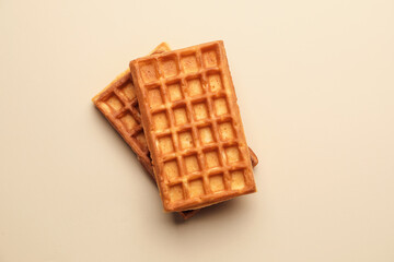 Delicious golden Belgian waffles on beige background