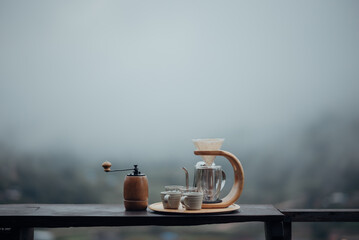 A drip coffee set with a Steel kettle, glass, and hand drip coffee maker in minimalist style with...