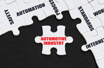 On a black background, puzzles with inscriptions, on a separate puzzle there is an inscription - Automotive Industry