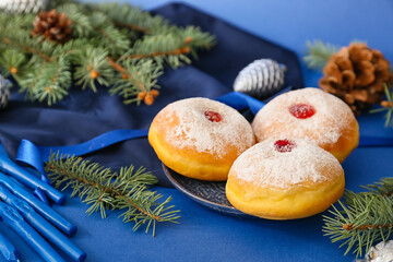 Sufganiyah for Hanukkah celebration with Christmas decor on color background
