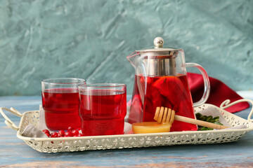 Tray with glasses of tasty lingonberry tea and honey on table