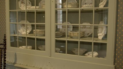 Tilt up over old cabinet with luxurious china dishes - Powered by Adobe