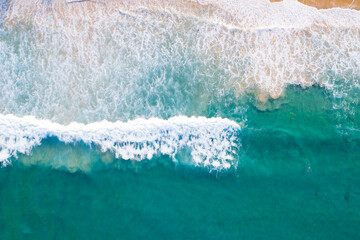 Fototapeta na wymiar Aerial view sandy beach and waves Beautiful tropical sea in the morning summer season image by Aerial view drone shot, high angle view Top down
