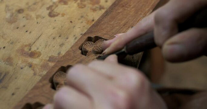 Close up of Chinese style carpenter carving on wood making traditional asian style furniture