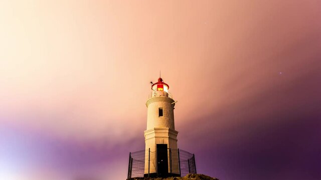 Tokarevsky lighthouse in Vladivostok. Time Laps. A picturesque lighthouse against the background of the starry sky. The Milky Way is moving around a beautiful old lighthouse.