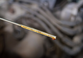 Oil probe of the car with a drop of engine oil.