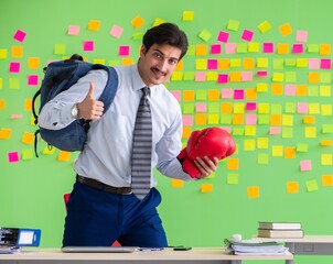 Man with boxing gloves in the office with many conflicting prior