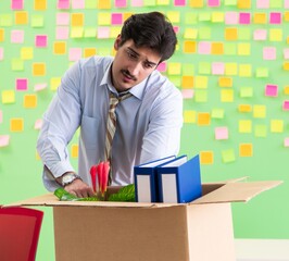Man collecting his stuff after redundancy in the office with man