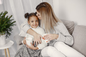 Caucasian mother with little african daughter at home