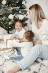 Caucasian mother with two little african daughters at home