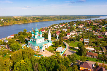 Scenic general aerial view of Russian town of Tutayev divided into two parts by Volga River overlooking Resurrection Cathedral on sunny summer day, Yaroslavl Oblast - Powered by Adobe