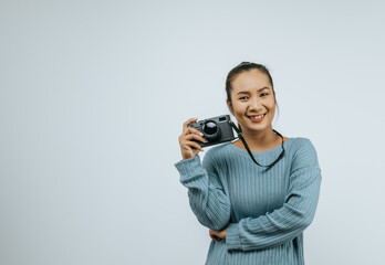 Portrait of Asian woman wearing casual clothes with a big smile on face,  holding a camera taking a picture. Isolated background in studio with blank space.
