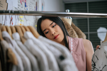 Smiley designer proud with her clothes design on hanger