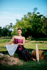 Young woman in beautiful Thai traditional clothes at rice field