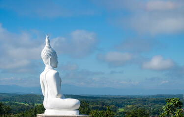 Great white Buddha statue in meditation posture on top of mountain, side view, outdoor landscape.Giant Buddha statue on the top of mount view point and landmark destination aerial landscape