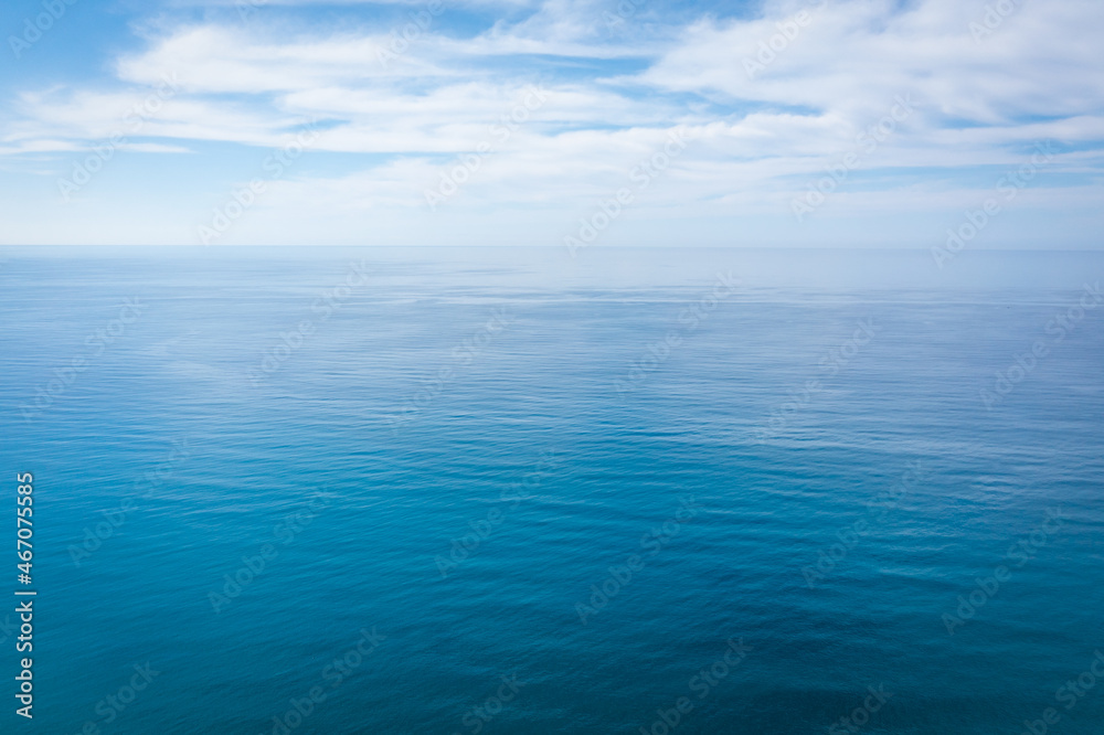 Wall mural closeup surface of calm ocean blue sea water with day light and clouds. abstract background texture.