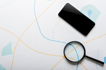 Magnifying glass and modern mobile phone on the background of map