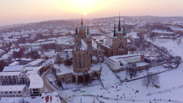 Aerial: Panning Shot Of Famous Cathedral And Residential Houses In City, Drone Flying Over Snowy Landscape During Sunset - Erfurt, Germany