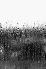 Naklejka na ściany i meble Background of condensation of water droplets on glass, humidity and fog behind glass, bad weather, rain
