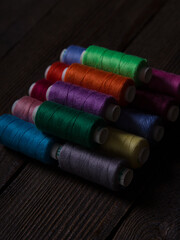 A set of sewing threads of different colours of brown on a wooden background